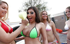 Four sexy kittens wash the car and one of them exposes awesome huge boobies