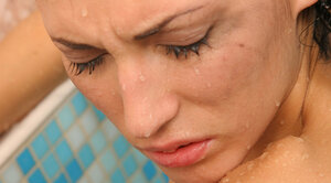 Twin-tailed brunette seductively poses undressed while relaxing in the bathroom