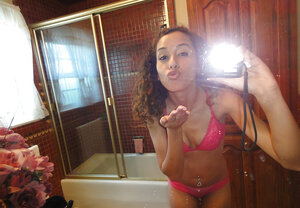 Latina with curly hair is taking sexy selfies while in underwear
