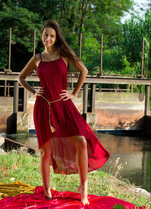 Alisa Amore disrobes to pose nude near a dam