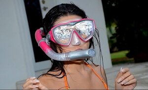 Latina 18-19 y.o. takes orange swimsuit and poses with diving mask and flippers