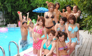 Asian girlfriends in skimpy bikinis rest half-naked with men poolside