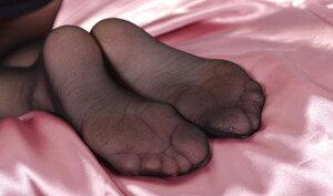 Flexible blonde in black pantyhose relaxes totally nude in bedroom