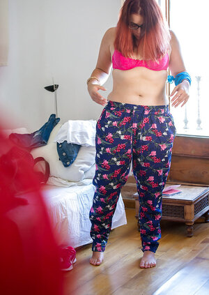 Plus-sized redhead on pink underwear to get fully dressed next to the window