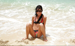 Luscious brunette peels swimming suit off to expose twat lips and pee on the beach