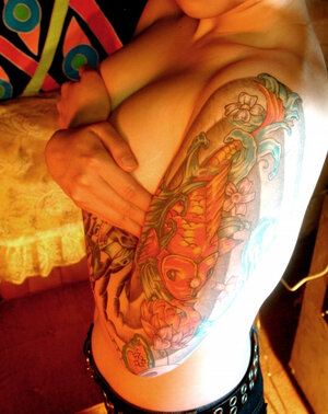 Asiatic teen flashes her tattoos everywhere on the tiny body in close-up