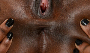 Sensuous black girl jumps on a white sofa to get strips naked and show her body