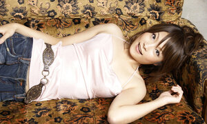 Japanese porn model poses on camera wearing a pink top and bell-bottom jeans